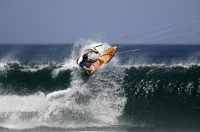 Kitesurfer riding a wave on the backhand