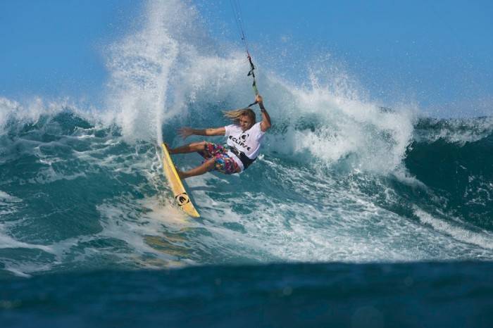 Kitesurfer carving a surfboard through a turn